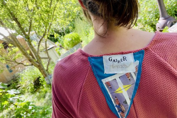 Back of a pink Gather Threads t-shirt withe label and fabric collage