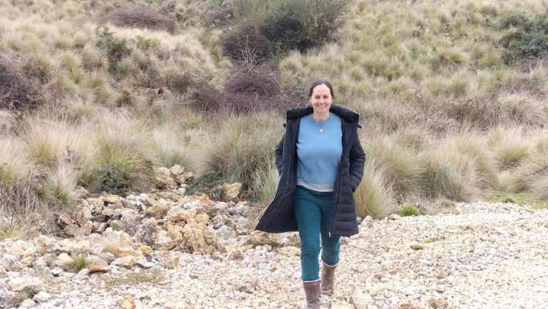Woman walking towards camera in rocky landscape